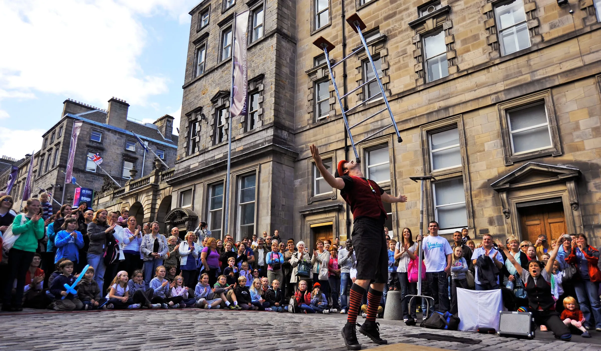 Un artista callejero hace malabares con muletas ante el público en la Royal Mile durante el Fringe