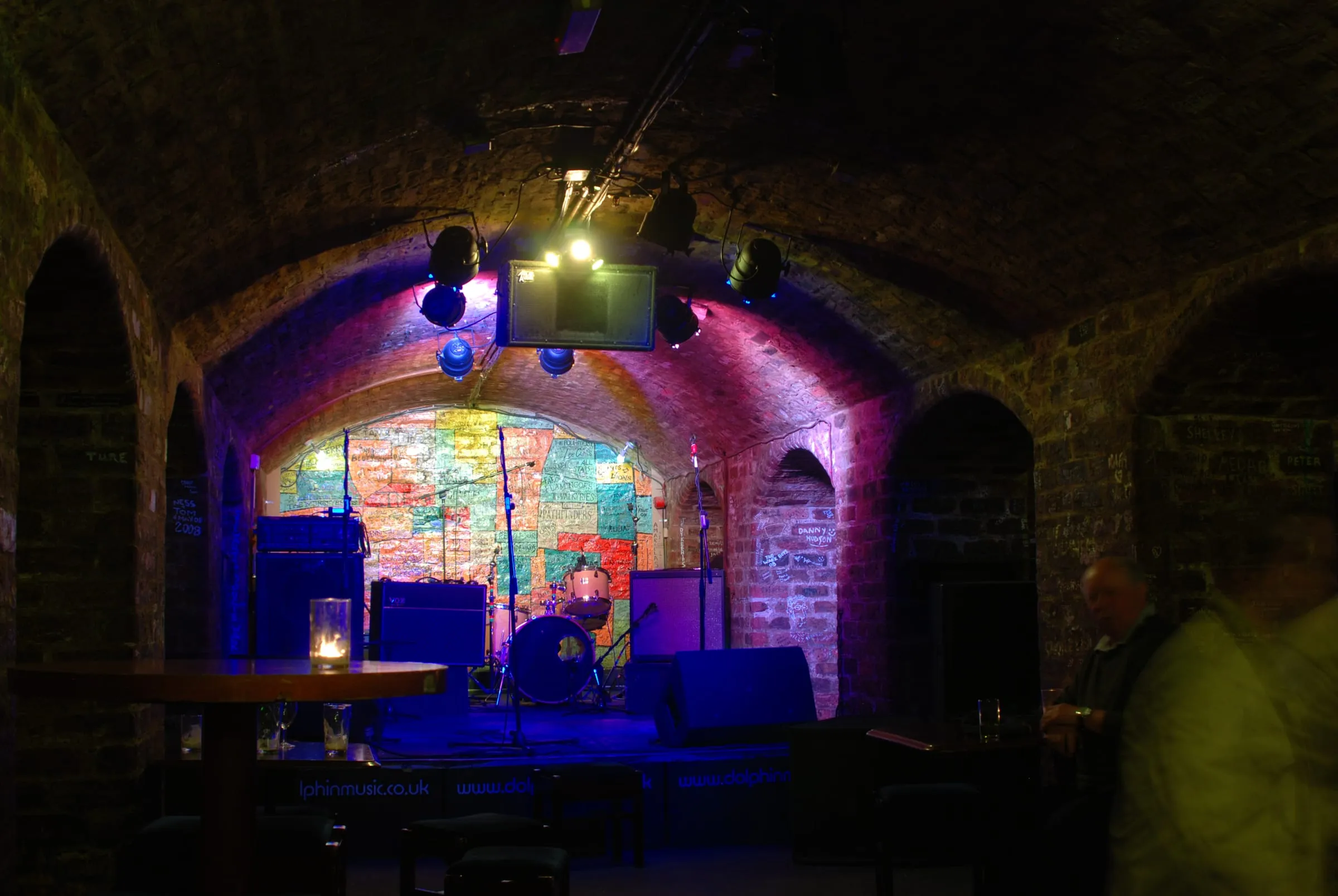 El escenario del Cavern Club iluminado, bajo las bóvedas de ladrillo