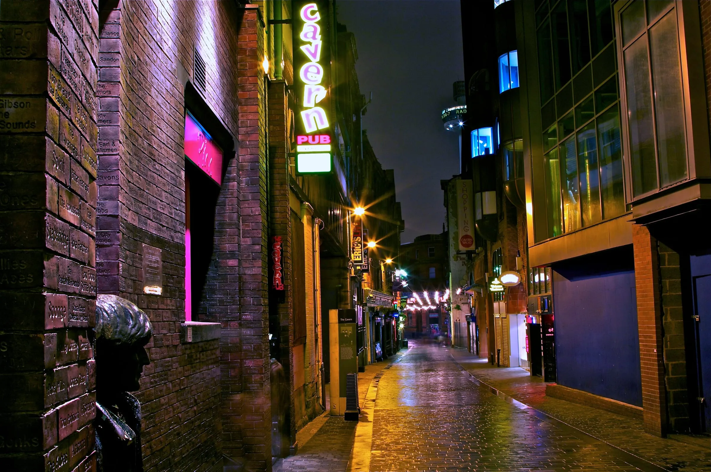 Mathew Street de noche, con el neón del Cavern Pub y la estatua de John Lennon apoyada en la pared
