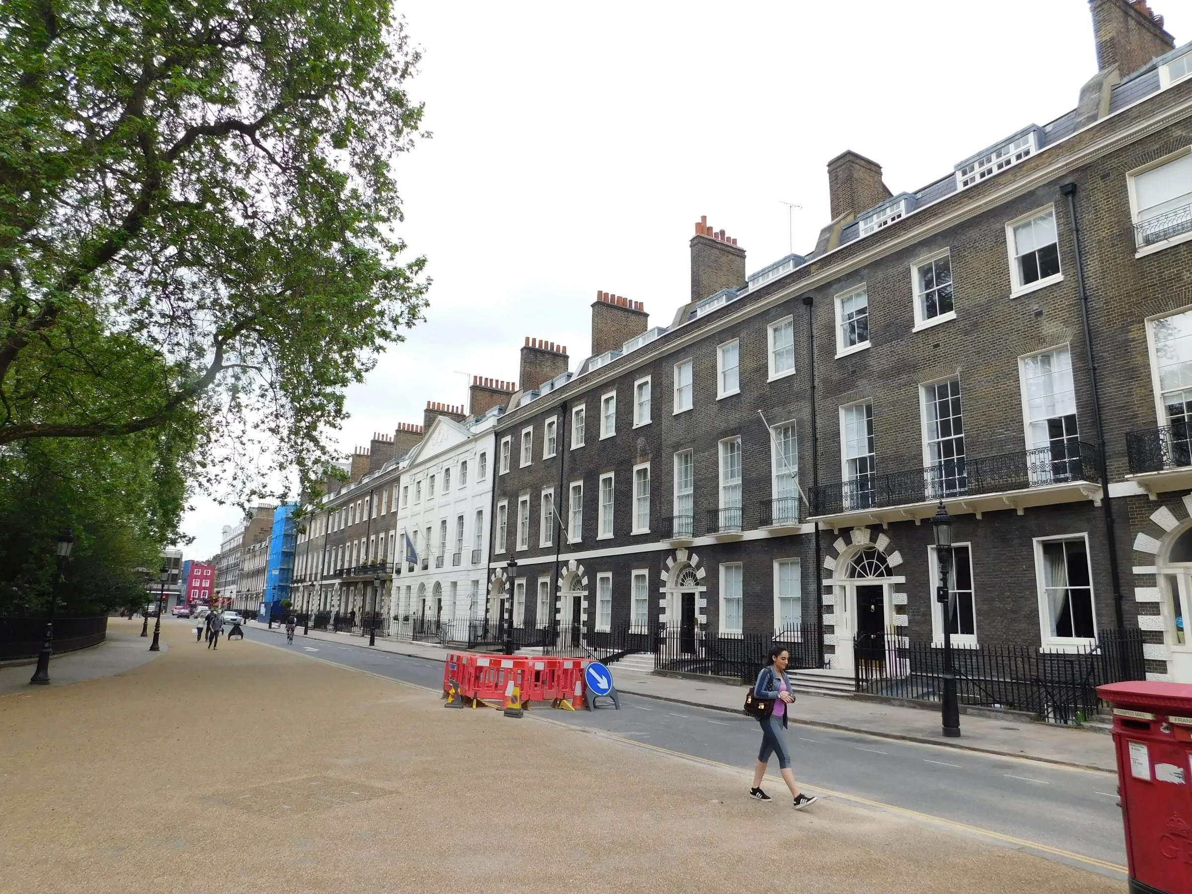Casas georgianas de ladrillo en una plaza de Bloomsbury, con una persona cruzando la calle
