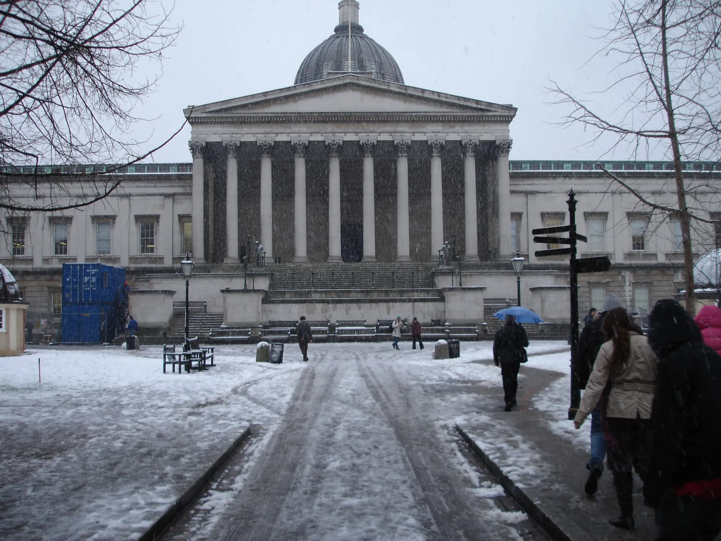 Pórtico neoclásico y cúpula del edificio principal de una universidad de Bloomsbury, con nieve en el patio